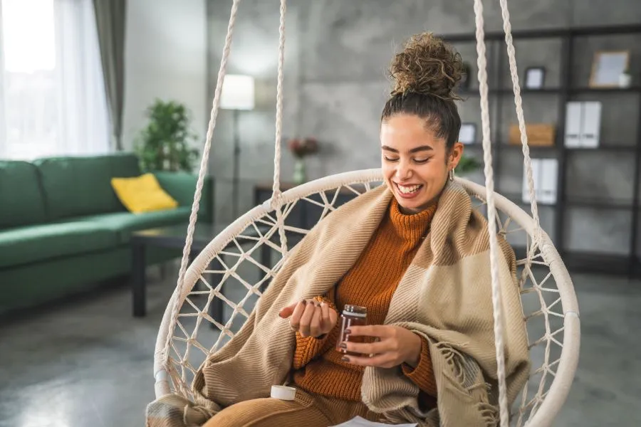 woman sitting on chair taking supplements